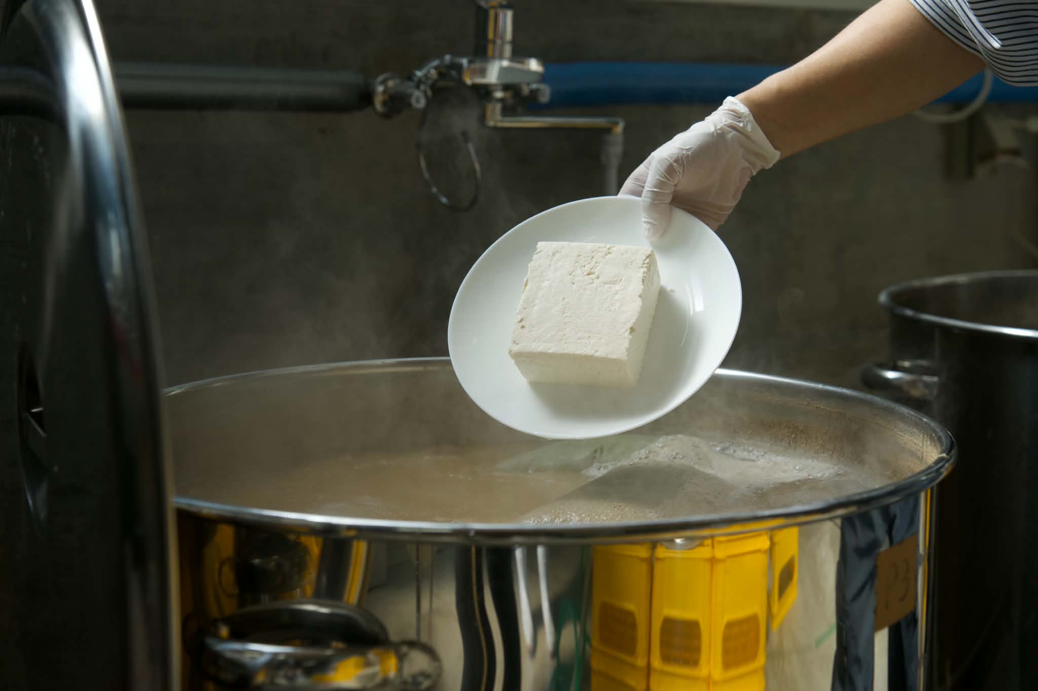 仕込み釜へ豆腐を加える様子